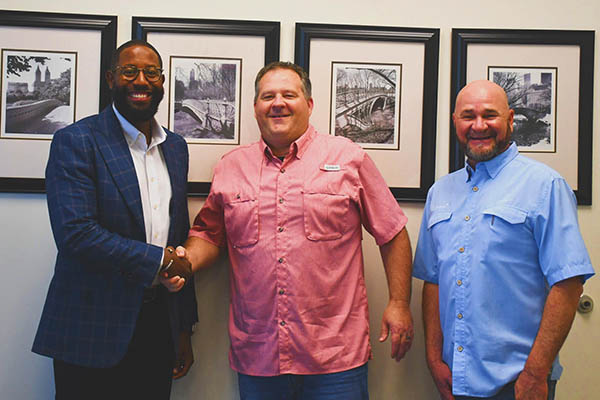 Nate Moore (left) purchases Lil Bucks and Does' Adventure & Learning Center. Duane Miller (center) and Jimmy Duhon.